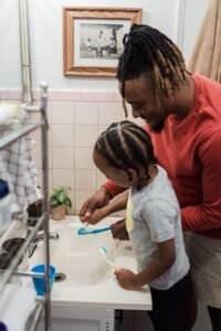 Father and son brushing teeth together to protect against grinding in Woodbridge