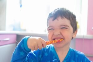 Young boy brushing his teeth to prevent cavities in baby teeth