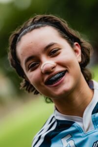 Teenage athlete smiling while wearing a sports mouthguard
