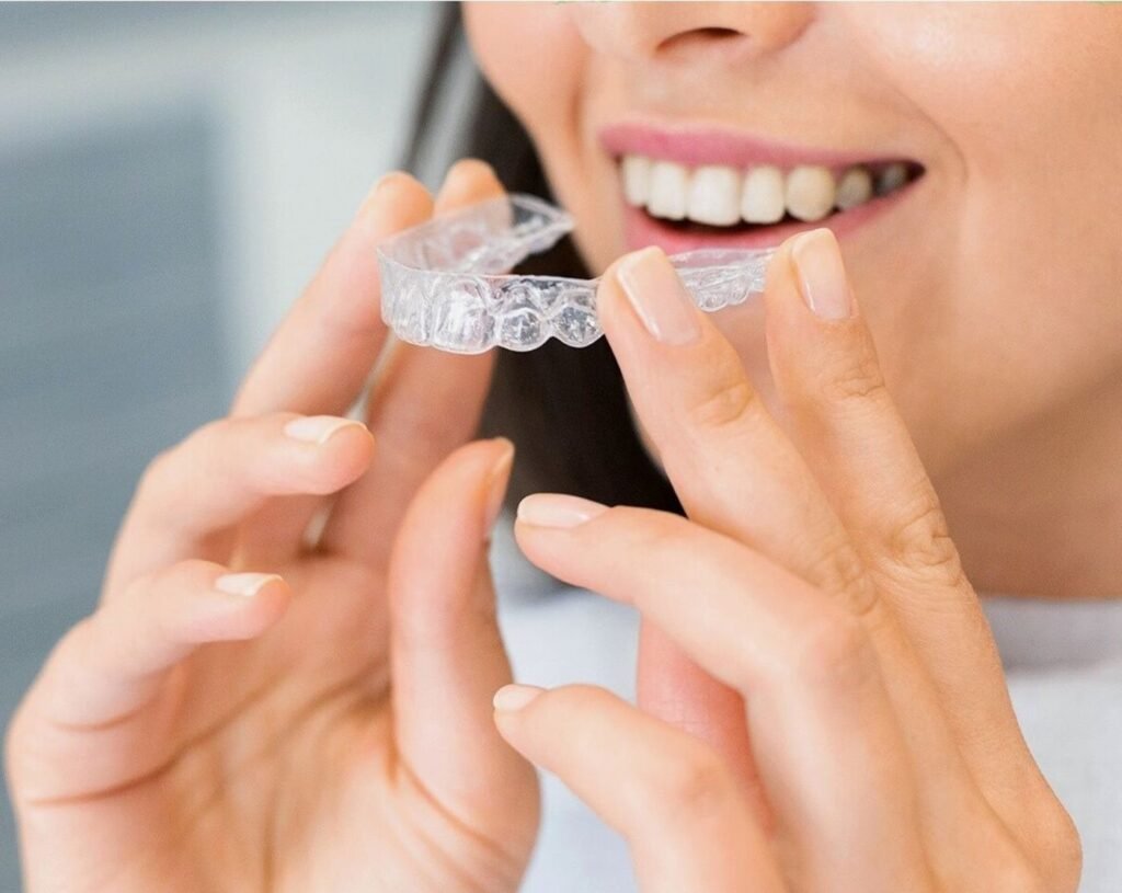 Invisalign in Woodbridge: patient holding a clear aligner at Peridot Dental Care