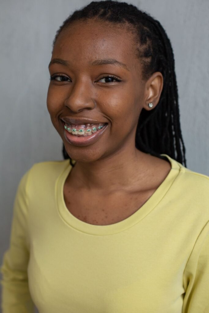 Smiling patient with braces comparing Invisalign vs braces in Woodbridge