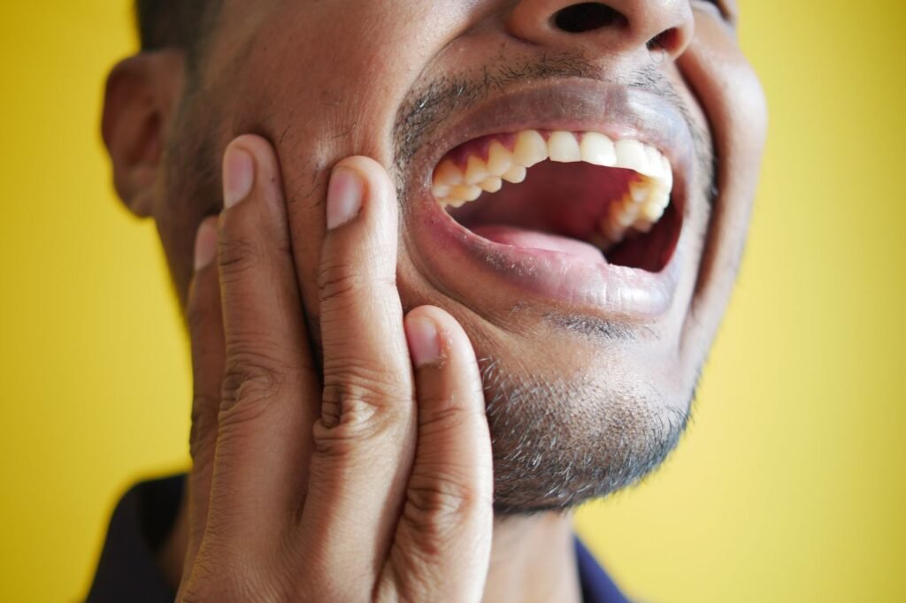 Man holding his cheek from a severe toothache needing an emergency dentist in Woodbridge